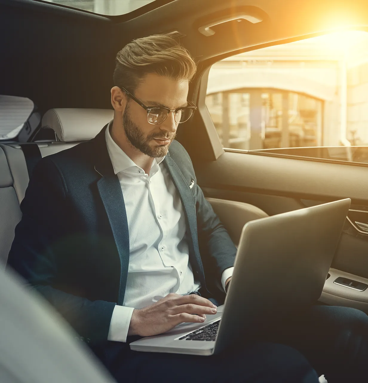 Professional reviewing trading data on a laptop in a car